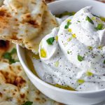 whipped feta in a bowl with a piece of naan.