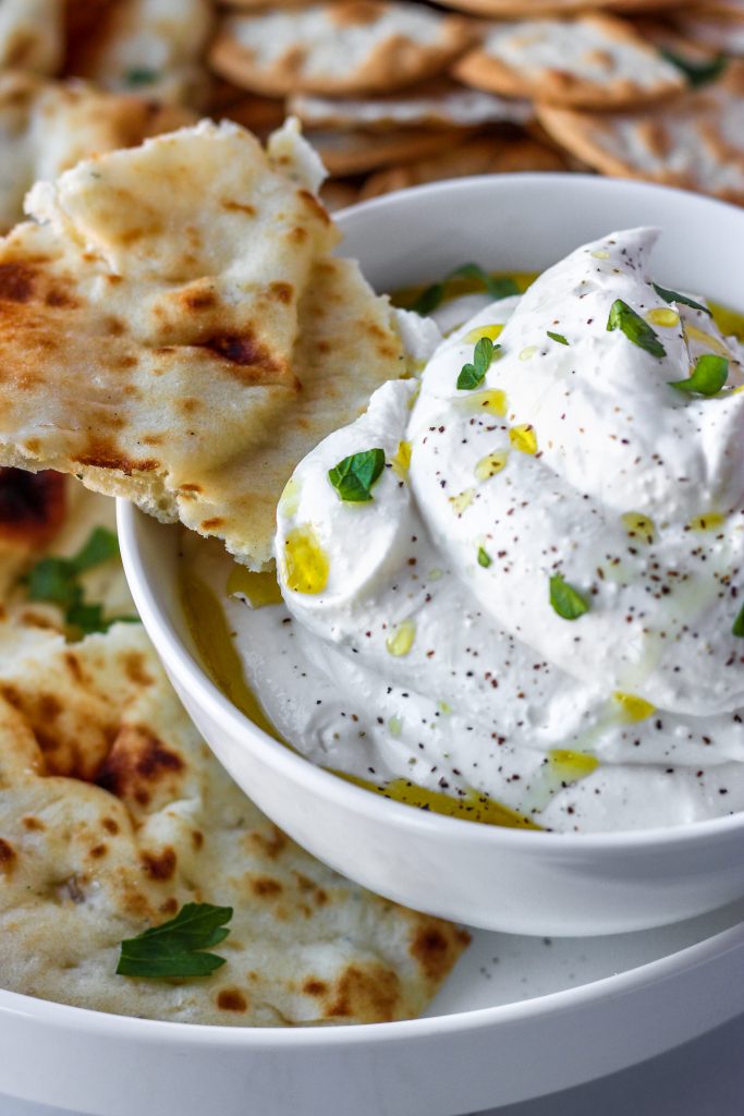 whipped feta in a bowl with a piece of naan.