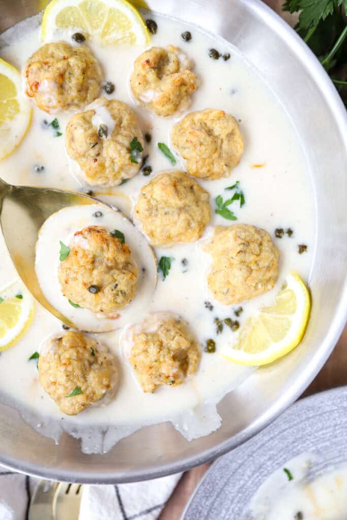 overhead photo of the chicken piccata meatballs in a stainless steel pan.