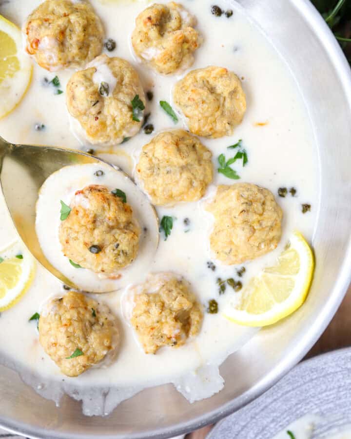 overhead photo of the chicken piccata meatballs in a stainless steel pan.