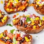 a grouping of Mexican stuffed sweet potatoes on a white marble surface.