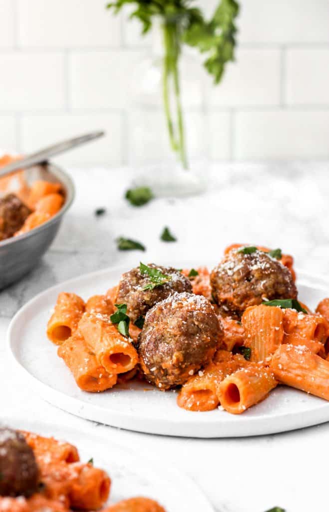 meatballs on rigatoni with vodka sauce on a white plate