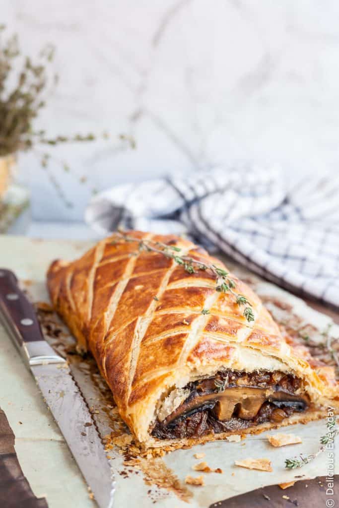 mushroom wellington with a knife on parchment paper.