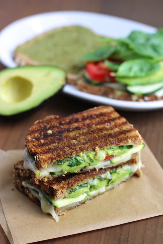 avocado grilled cheese on brown paper on a wood board.