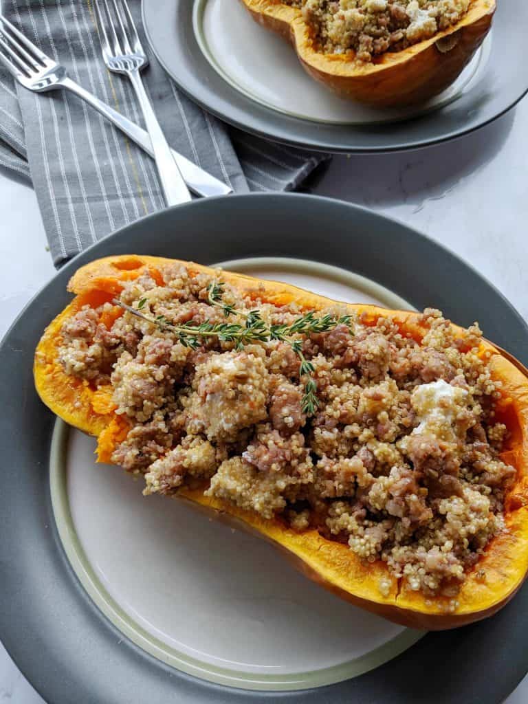 overhead view of the stuffed butternut squash with a napkin and two forks.