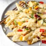 creamy vegetable pasta on a grey plate