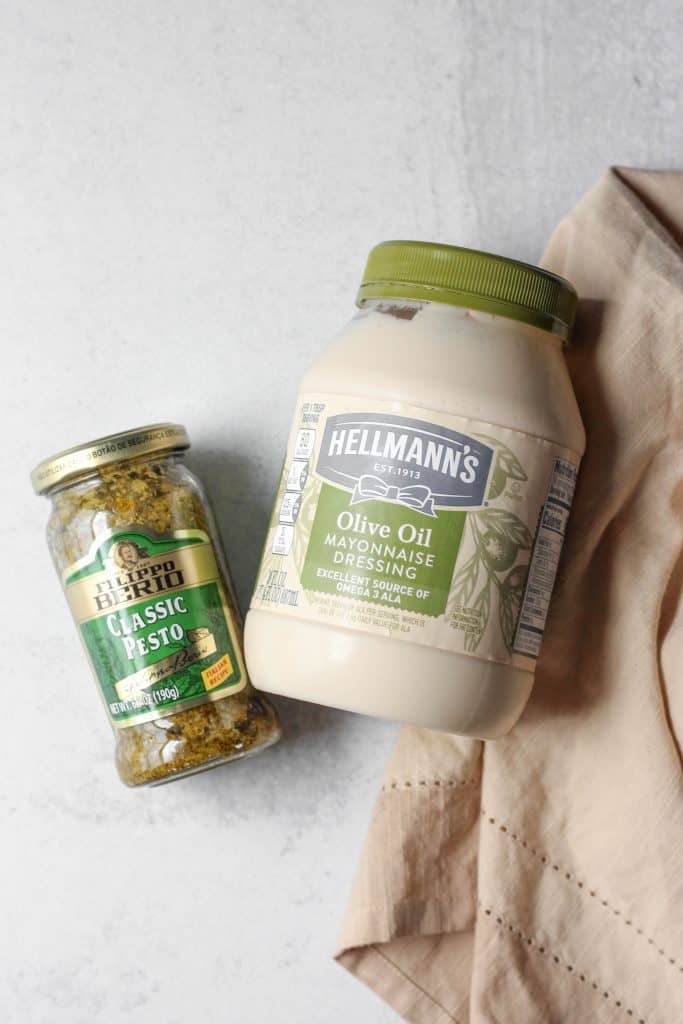 overhead shot of a jar of pesto and a jar of mayo.