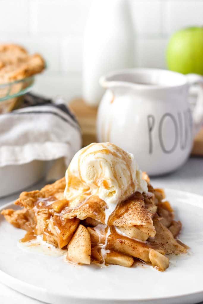 apple piece slice with vanilla ice cream and drizzled sauce over top.