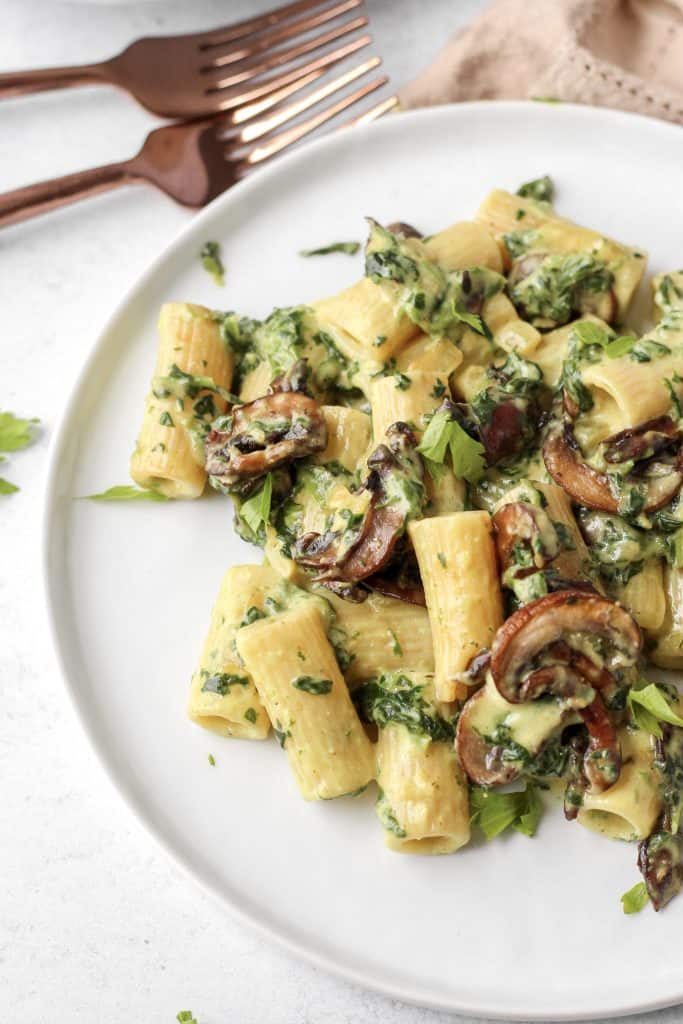 a round white plate of the creamy curry pasta with parsley.