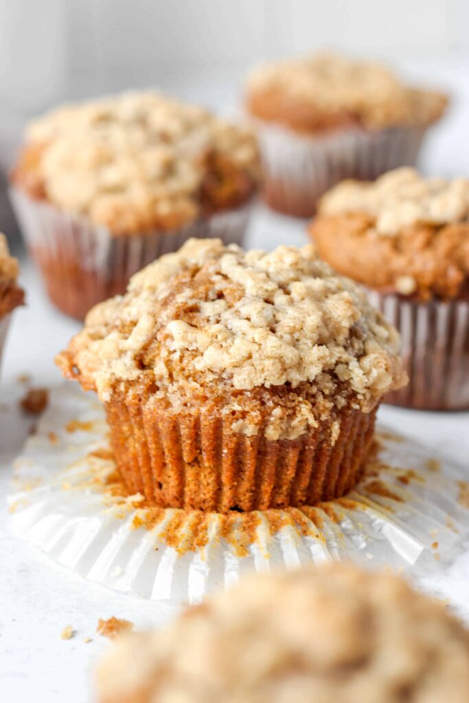 closer shot of the unwrapped muffin with several muffins in the background.