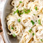overhead shot of alfredo sauce with spiraled noodles.