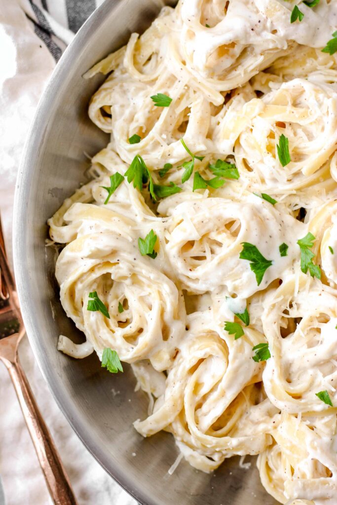 overhead photo of alfredo sauce with spiraled noodles.