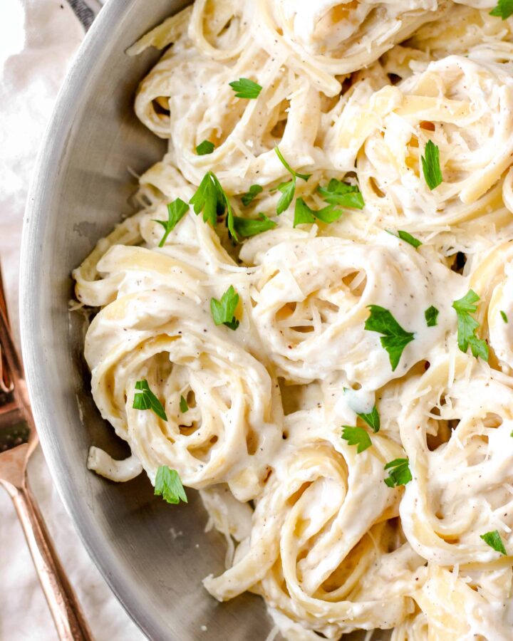 overhead shot of alfredo sauce with spiraled noodles.