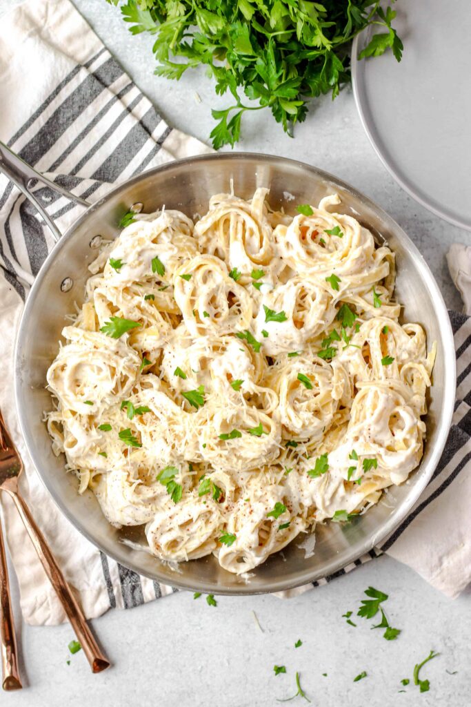 overhead photo of a silver pan with spiraled noodles of pasta.