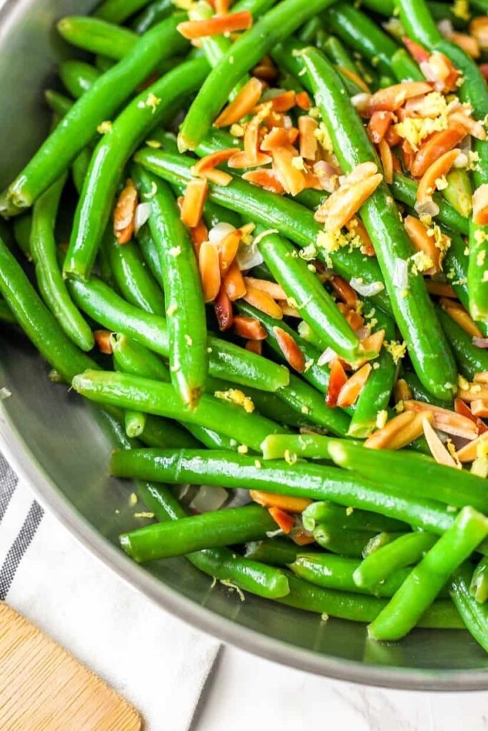 close shot of the green beans with toasted almonds and lemon zest