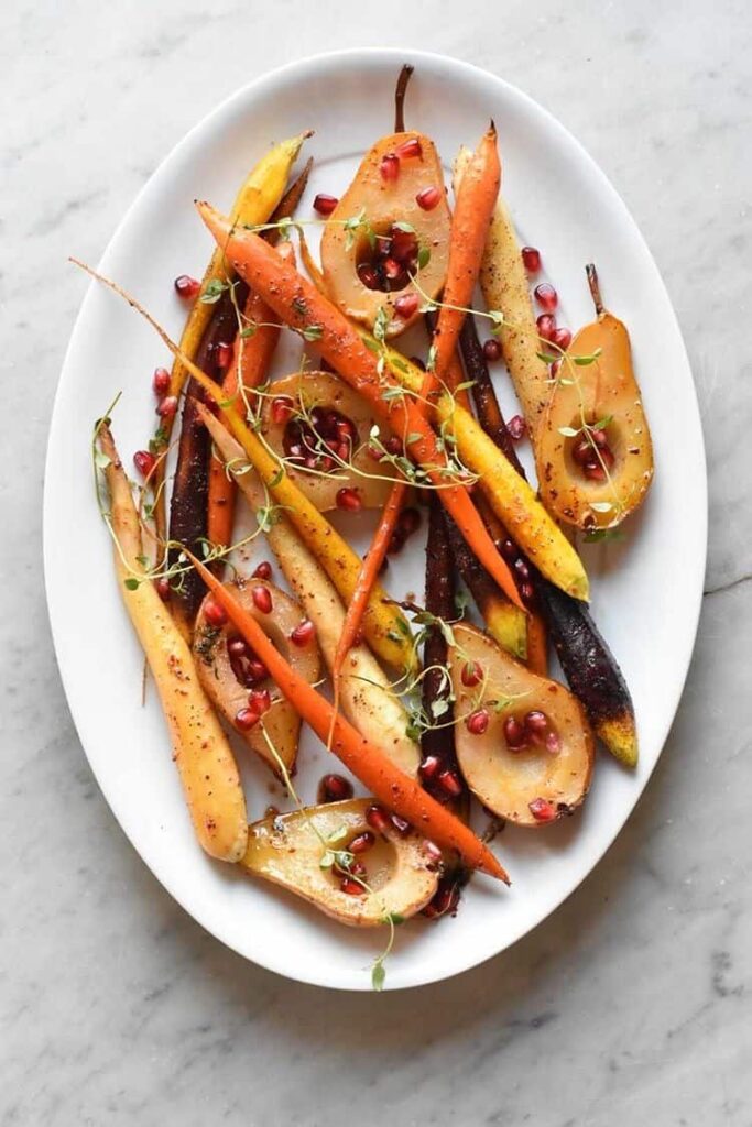 overhead shot of a platter with the carrots, pears, and pomegranate seeds. 