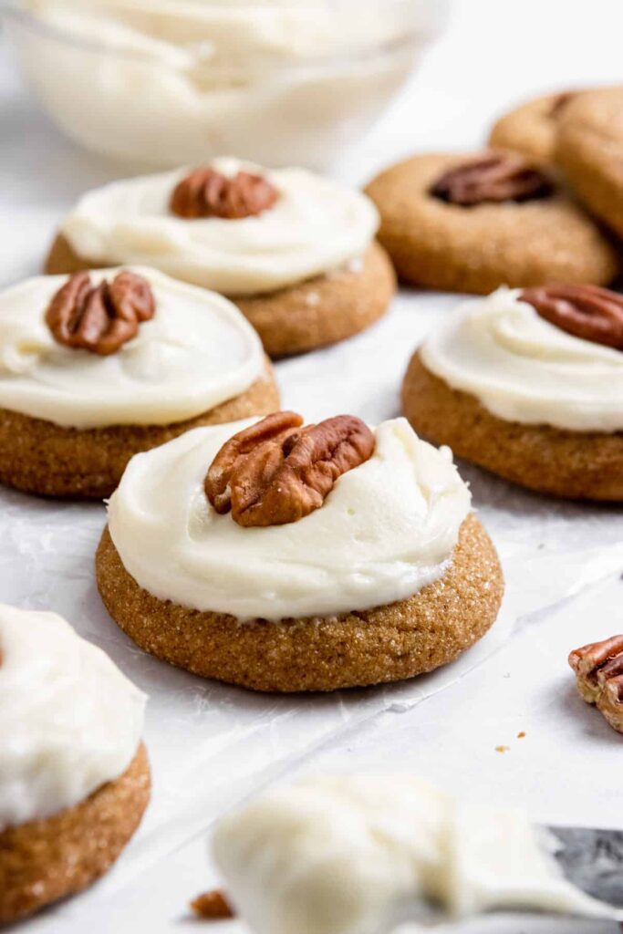 molasses cookies topped with frosting and a pecan.