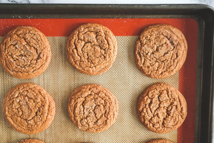 overhead shot of gingersnap cookies on a baking sheet.