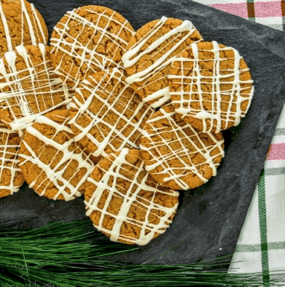 overhead shot of a plate of gingersnaps drizzled with white chocolate.