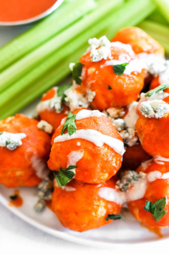 close shot of the meatballs drizzled with blue cheese sauce and parsley.