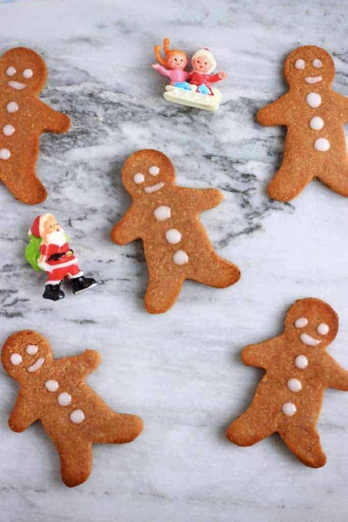 overhead shot of decorated gingerbread men on a white marble surface.