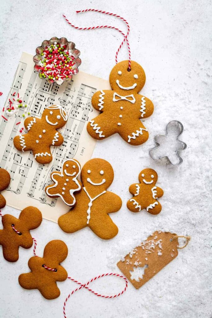 overhead shot of decorated gingerbread cookies on sheet music.