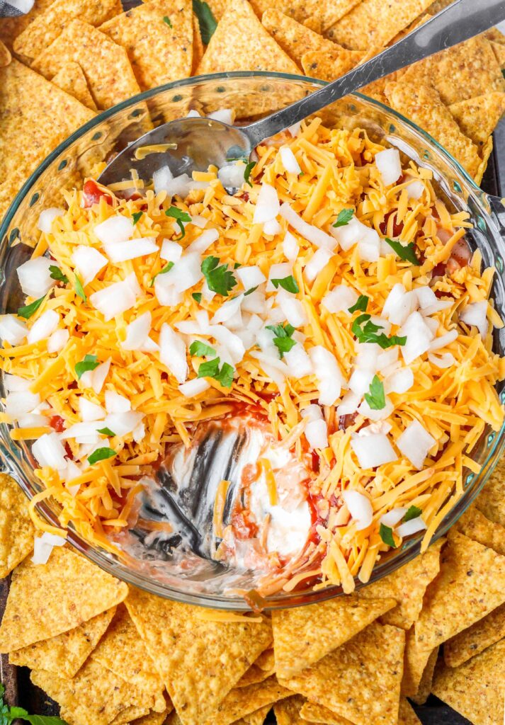 overhead shot of the cream cheese salsa dip with a scoop taken out so it shows the layer of cream cheese and the layer of salsa.