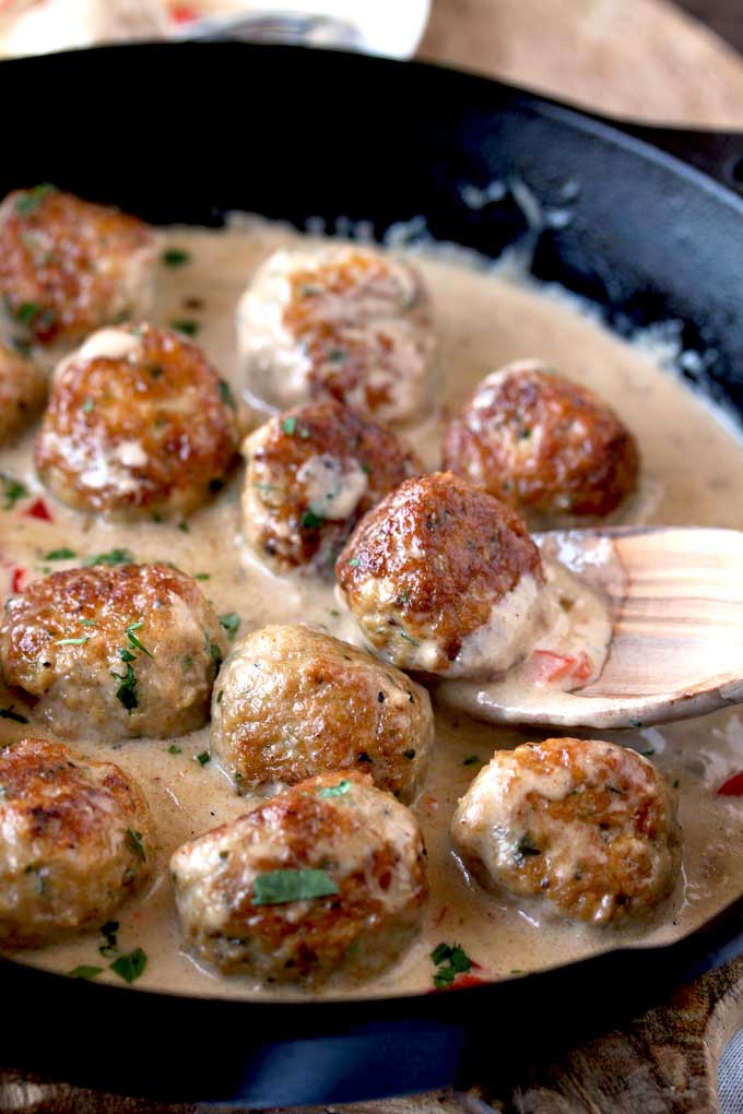chicken meatballs in a Cajun cream sauce with a spook in a skillet.