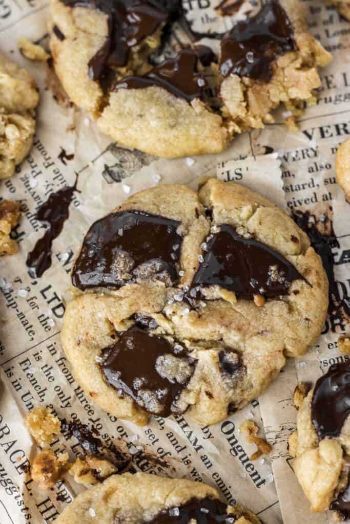 close shot of the chocolate chunk cookies with sea salt on brown newsprint paper.