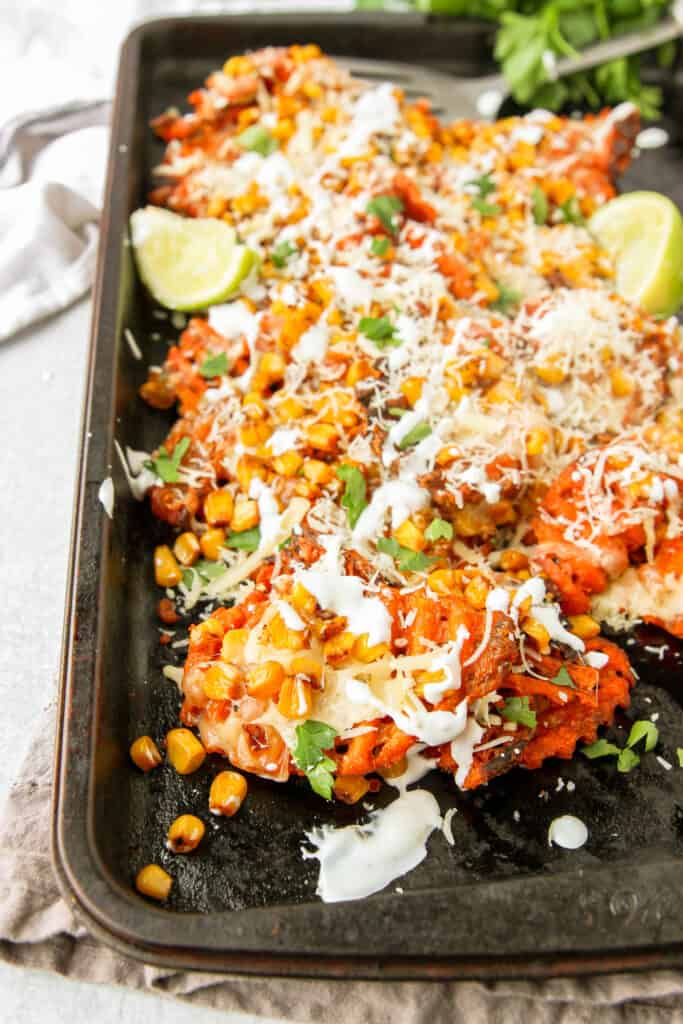 the Mexican street corn waffle fries on a baking tray with parsley in the back.