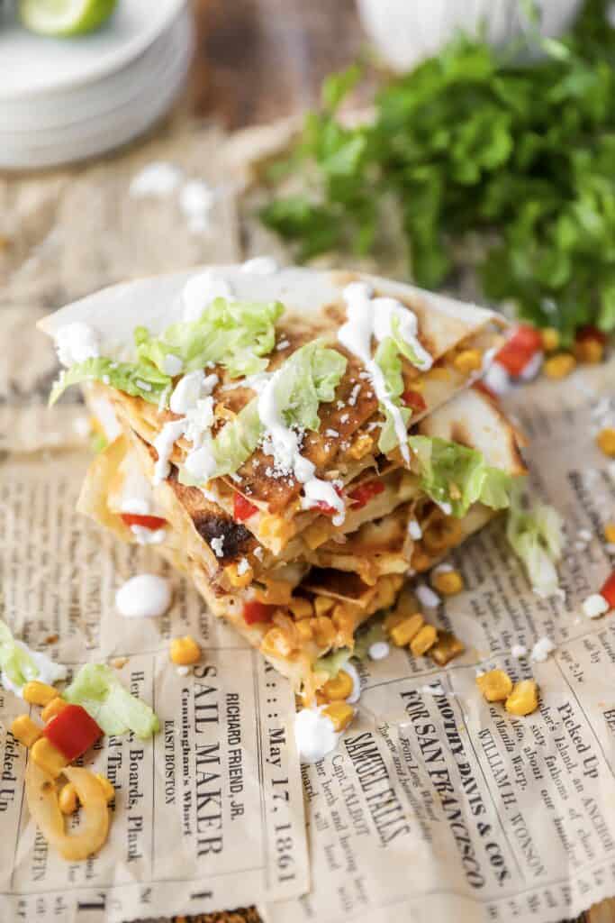 overhead shot of the quesadillas on brown newsprint paper.