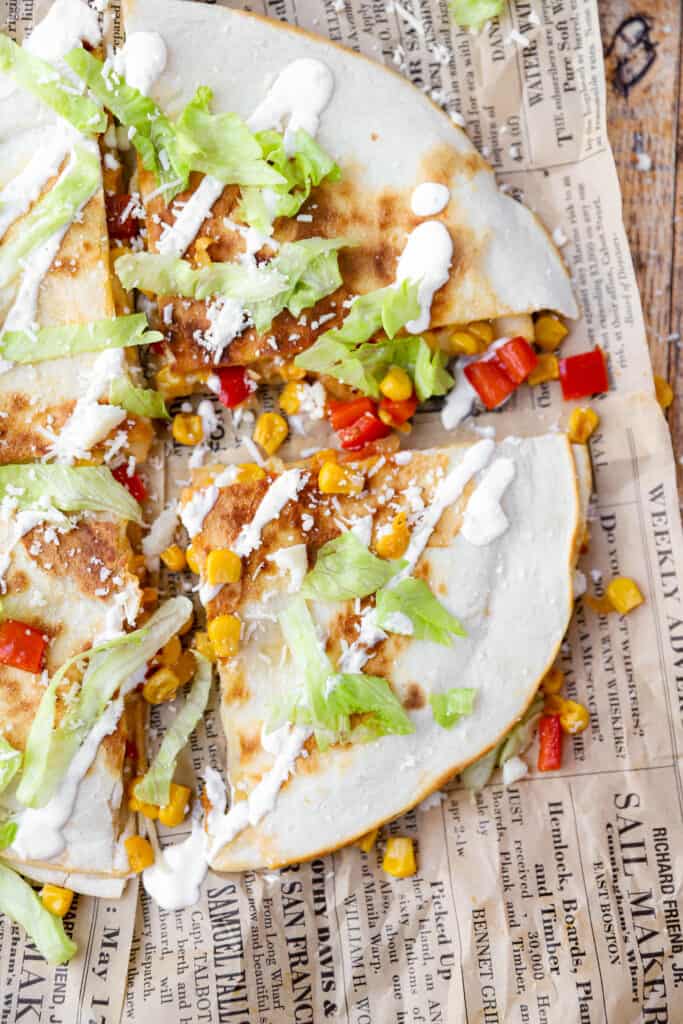 overhead shot of the corn and red pepper quesadillas, focusing on one triangle slice...on brown newsprint paper.