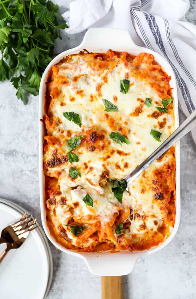 overhead shot of the baked penne vodka in the white casserole dish with a silver spoon.