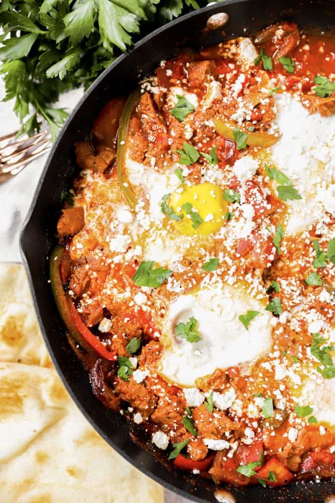 overhead shot of the shakshuka with naan off to the side. 