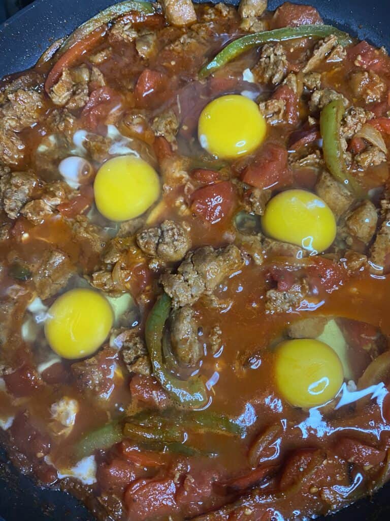 the eggs added to the shakshuka, raw eggs not cooked yet.