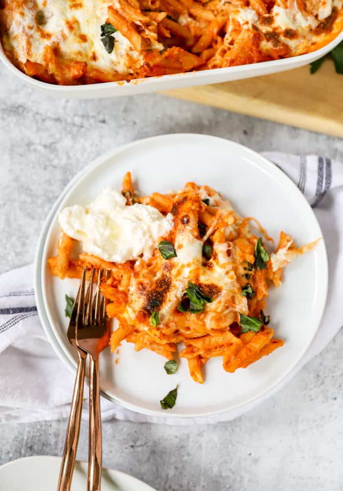 overhead shot of the pasta on a round white plate with two bronze forks.