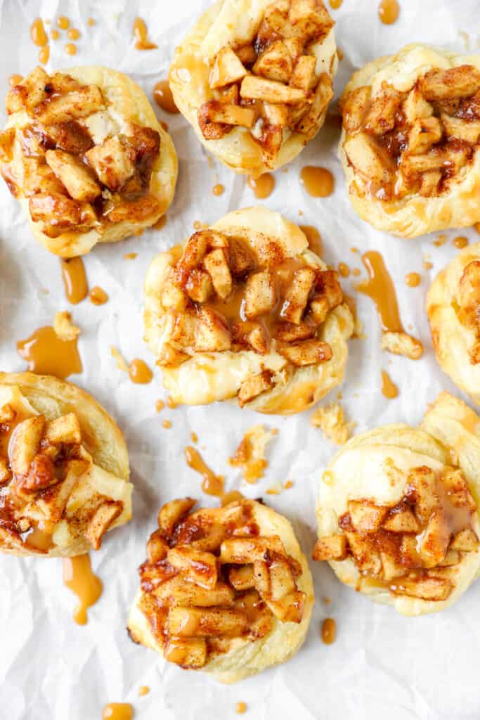 overhead shot of the apple danishes on parchment paper with caramel drizzle.