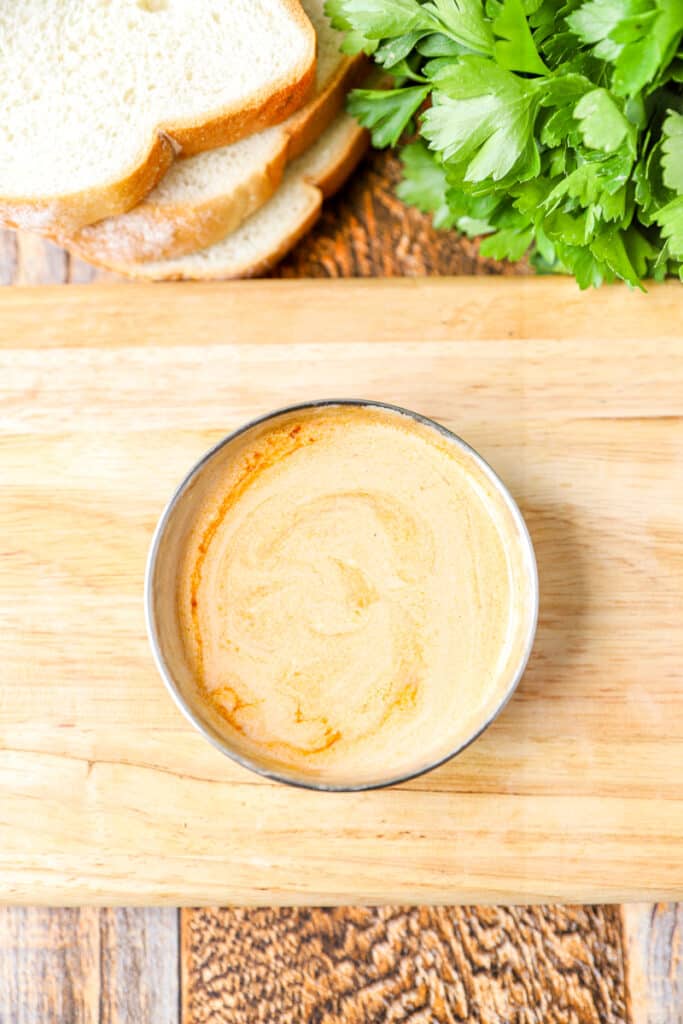 overhead shot of a small bowl of chipotle crema on a wood surface.