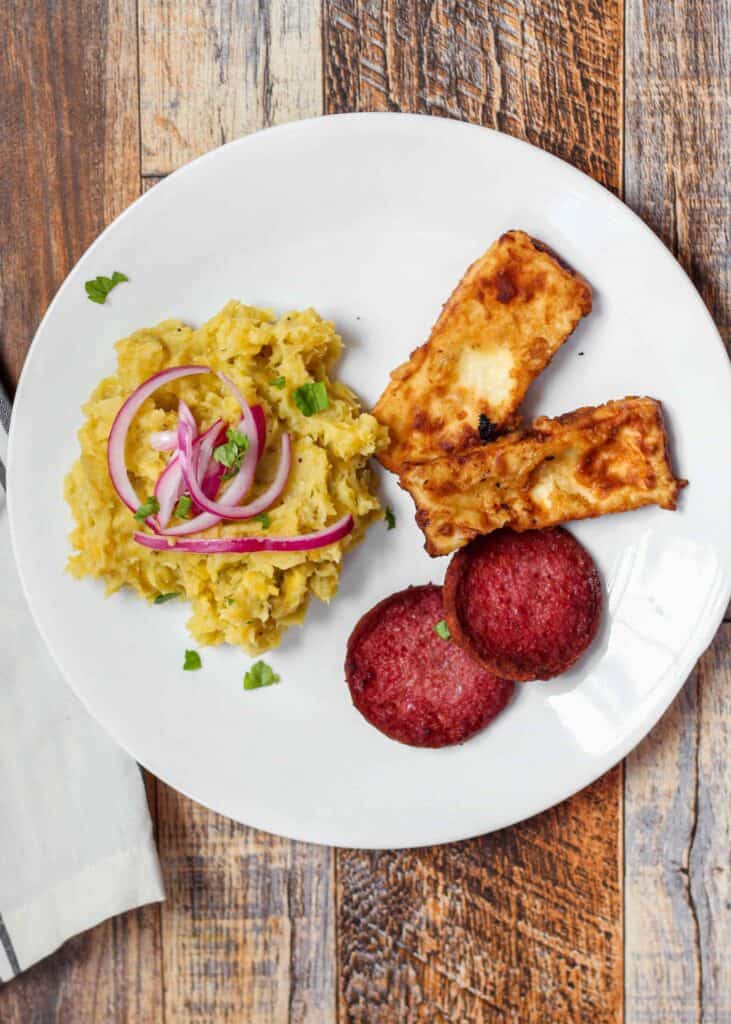 overhead shot of  a plate of mangu topped with the pickled red onions.