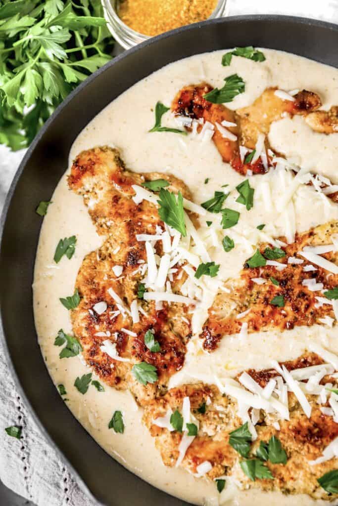 overhead shot of the cooked chicken breasts in the pan of the creamy Cajun sauce.