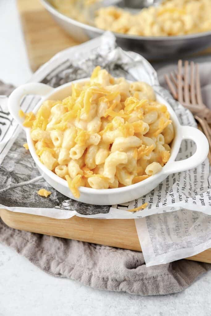 stovetop mac and cheese in a white dish on newsprint paper.