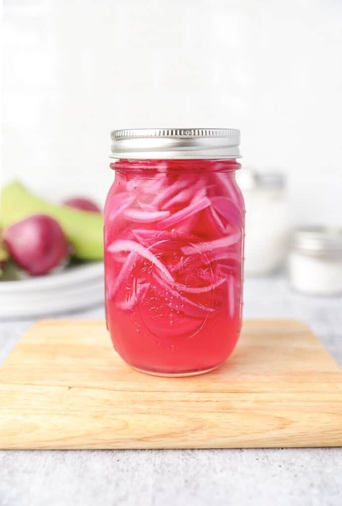 the pickled red onions in a mason jar. Onions on plantains in the back.