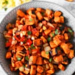 overhead shot of sweet potato home fries in a grey bowl.