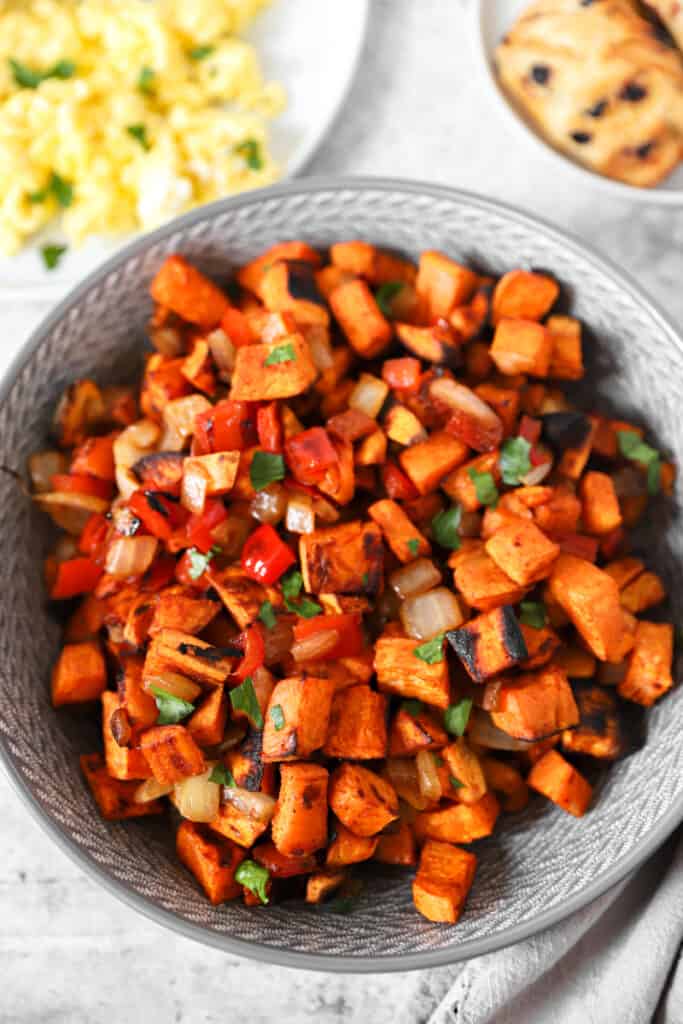 overhead shot of sweet potato home fries in a grey bowl.