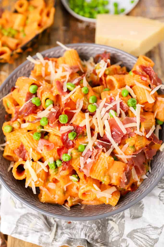 rigatoni vodka pasta topped with crispy prosciutto in a grey bowl