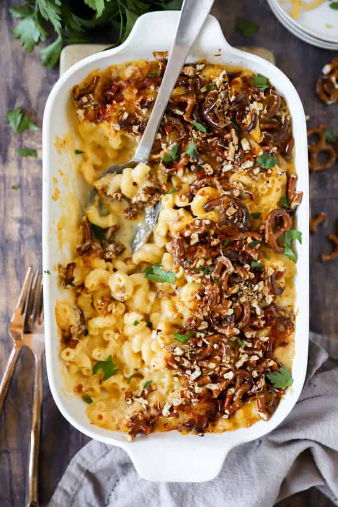 overhead photo of the beer mac and cheese in a white casserole dish on a wood surface.