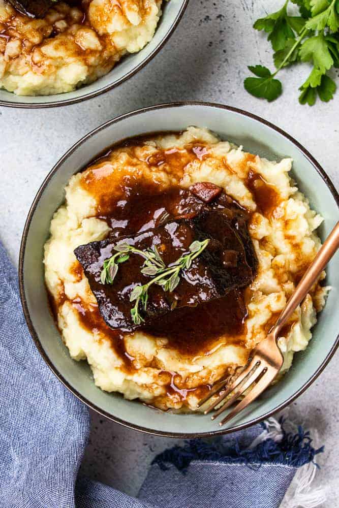 overhead shot of the braised short ribs on a plate of mashed potatoes