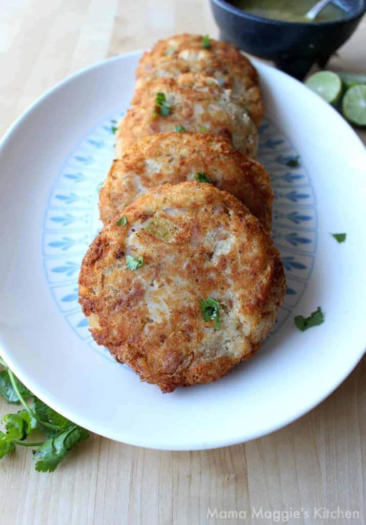 the potato and tuna patties on a white and blue serving platter.