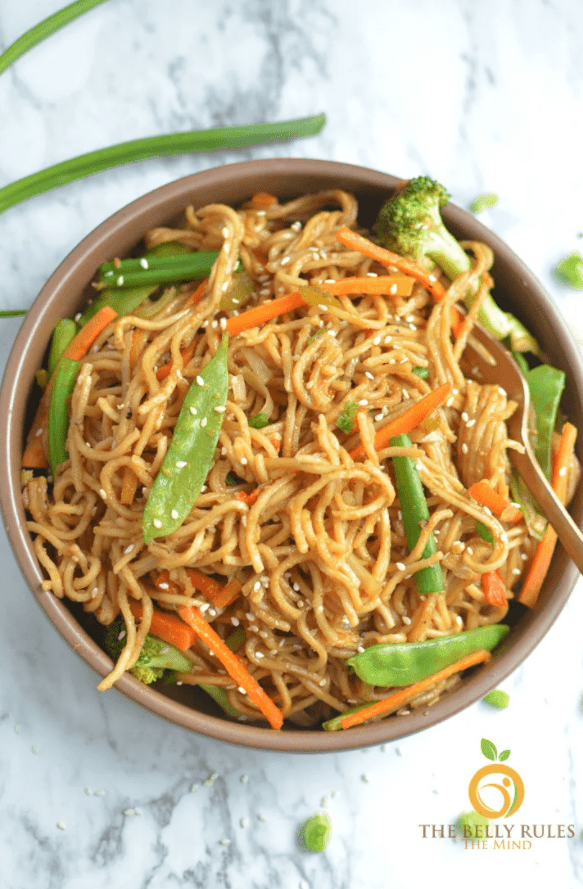 overhead shot of the vegetable chow mein in a brown bowl.