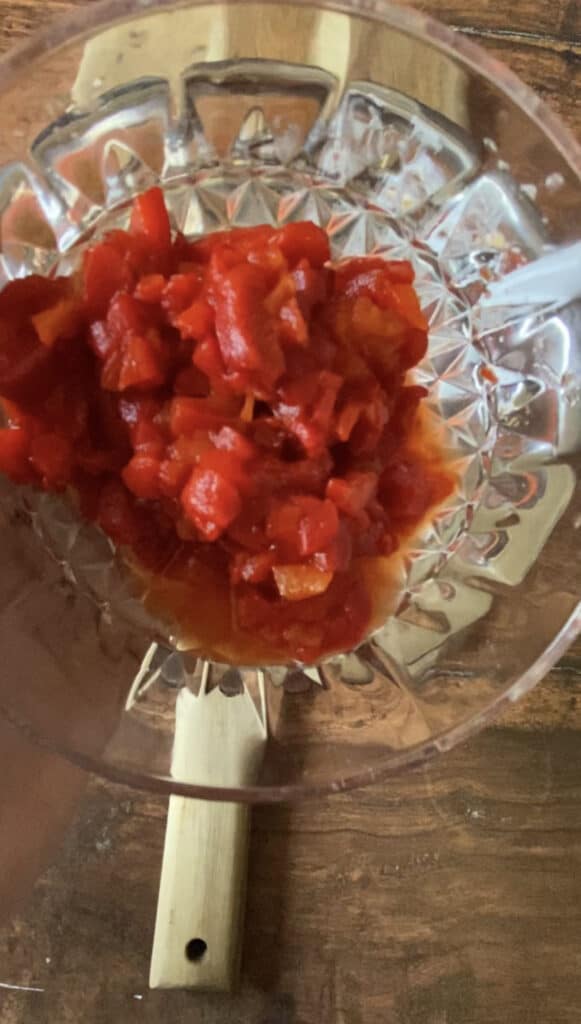 overhead shot of a glass bowl with chopped pimentos